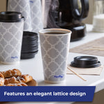 Steaming Hefty gray lattice-pattern disposable cup filled with coffee, lids and sugar jar visible on counter