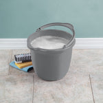 Sterilite gray plastic bucket with handle filled with soapy water, placed on tiled floor with cleaning brush and sponge nearby
