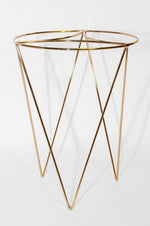 Studio shot of a Mainstays gold metal plant stand casting soft shadows on white