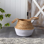 Styled boho jute and white cotton basket with looped handles on a wood floor near rustic door