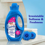 Suavitel Field Flowers bottle staged next to folded towels and blue flowers with text ‘Irresistable Softness & Freshness’