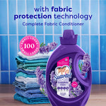 Suavitel lavender fabric conditioner bottle beside folded towels and lavender sprigs against blue tiled background