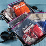 Open suitcase packed with multiple clear Hefty slider bags organizing folded clothing labeled with weekday tags