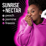 Woman in a pink sweater holding fabric to her face beside text listing Sunrise + Nectar scent notes peach, jasmine, freesia