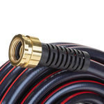 Macro view of a brass female coupling and black strain relief on a coiled dark garden hose with red stripe