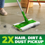 Swiffer Hair Magnet mop in use on floor picking up hair and dust near a chair leg, with 2x pickup callout