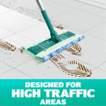 Swiffer mop head with cloth attached mopping a tiled floor showing muddy footprints and text 'Designed for High Traffic Areas'.