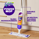 Swiffer PowerMop standing on a hardwood floor with labeled callouts for pole, solution and microscrubbers