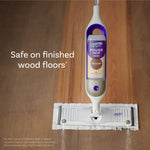 Swiffer Power Mop device on a wood floor with a white cleaning pad attached and text noting safe on finished wood floors