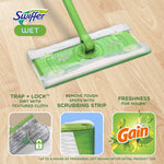 Swiffer wet mop head on a wood floor with callouts showing trap+lock textured cloth, scrubbing strip, and Gain freshness icon.