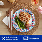 Styled table setting with a Dixie Ultra paper plate featuring a red, white and blue patterned rim and plated meal
