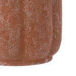 Tight crop of the textured terracotta surface of a scalloped ceramic planter showing speckled finish.