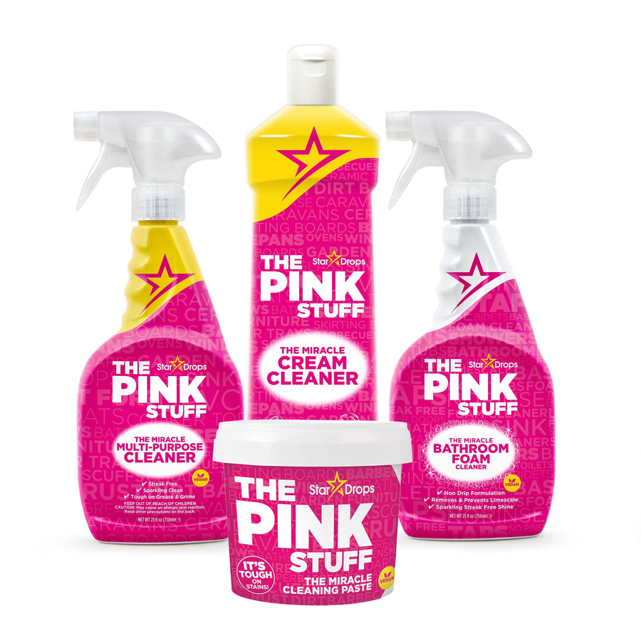 Studio shot of four pink The Pink Stuff cleaning products including paste tub, cream cleaner and two spray bottles on white background