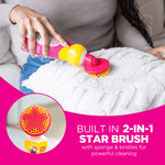 Person using The Pink Stuff bottle with star-shaped scrub brush on a white textured cushion in a lifestyle shot