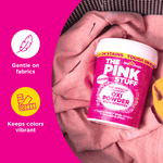 The Pink Stuff Oxi Powder tub pictured on pink fabric with icons for gentle on fabrics and keeps colors vibrant