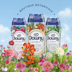 Three Downy Boutique Botanicals bottles, including Citrea in the center, arranged with floral illustrations against a sky backdrop.