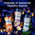 Three Downy Cozy Collection bottles, including Cuddle Weather center, arranged on a dark blue textured background with seasonal decor.