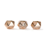 Three empty polished copper faceted succulent pots lined up on a white background
