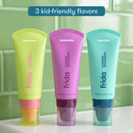 Three colorful Frida toothpaste tubes standing side by side labeled watermelon, bubble mint, and sweet mint