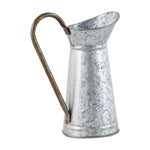 Three-quarter view of a galvanized pitcher with prominent curved brown handle and narrow spout