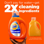 Hand holding an orange Tide Ultra OXI Boost bottle next to a plain orange bottle with headline about 2X cleaning ingredients