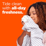 Person smelling a freshly laundered striped shirt next to text promoting Tide all-day freshness on orange background