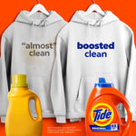 Two hoodies hung on hangers with one stained and one labeled “boosted clean” beside Tide bottle