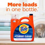 Tide Ultra Hygienic Clean bottle on a countertop with folded laundry and text 'More loads in one bottle' in the background