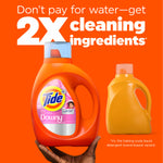 Hand holding an orange Tide + Downy bottle beside a generic orange jug with headline about 2X cleaning ingredients