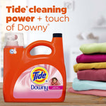 Orange Tide detergent jug with Downy label on a table next to a neatly folded stack of colorful clothes and headline text about Tide cleaning power.