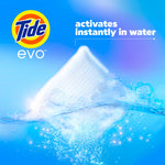 Close-up of a Tide Evo detergent tile partially submerged in water with bubbles and text stating activates instantly in water