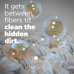 Close-up infographic of fabric fibers with translucent cleaning spheres and text 'It gets between fibers to clean the hidden dirt'