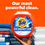 Hand holding a Tide Oxi Boost container against stacked folded laundry with orange background and headline text