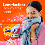 Lifestyle graphic of a woman smelling a soft blue towel with Tide PODS 4 in 1 Downy packaging and pink petals.