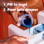 Close-up of hands pouring blue Tide liquid from measuring cap into a washer detergent drawer with instructions