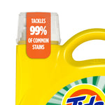 Close crop of a yellow Tide jug showing the handle, cap and orange label reading 'TACKLES 99% OF COMMON STAINS'