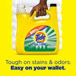 Hand holding a yellow Tide Simply All In One detergent jug against a stacked white towel background and yellow backdrop