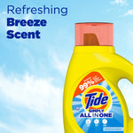 Close-up of the top half of a yellow Tide Simply All in One bottle set against a blue sky background with text reading Refreshing Breeze Scent.