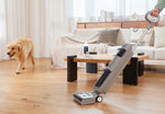 Tineco cleaning solution bottle on a coffee table while a person uses a Tineco floor cleaner and a dog walks in the background