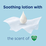 Single tissue with a droplet of lotion above it and text 'Soothing lotion with the scent of Vicks' on a pale blue background.