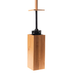 Toilet brush with bamboo handle inserted into a tall square bamboo holder on white