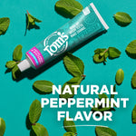 Tom's of Maine toothpaste tube placed on a teal background surrounded by fresh peppermint leaves and 'NATURAL PEPPERMINT FLAVOR' text.