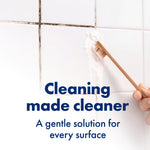 Close-up of a toothbrush scrubbing tile grout with paste and text 'Cleaning made cleaner' promoting baking soda