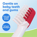 Close-up of toothbrush head showing extra soft rounded bristles and soft gum massagers against a light blue background