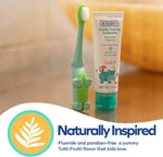 Dr. Talbot's toothpaste tube and green alligator training toothbrush standing on a wooden surface