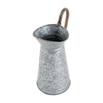 Top-down angled view into a galvanized pitcher showing the spout, interior, and curved handle