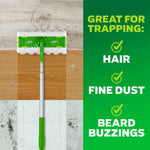 Top-down view of a Swiffer Hair Magnet mop head on a wood and tile floor with copy listing items it traps: hair, fine dust, beard buzzings