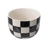 Top-down three-quarter view of a round ceramic planter with a black-and-white checker pattern, shown empty.