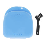 Top view of closed blue plastic retainer/braces storage case beside a small black multi-bristle cleaning brush