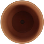 Top-down view into terracotta planter interior showing central drainage hole and smooth inner walls.